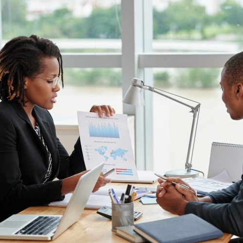 Business woman showing diagram and explaining information to entrepreneur